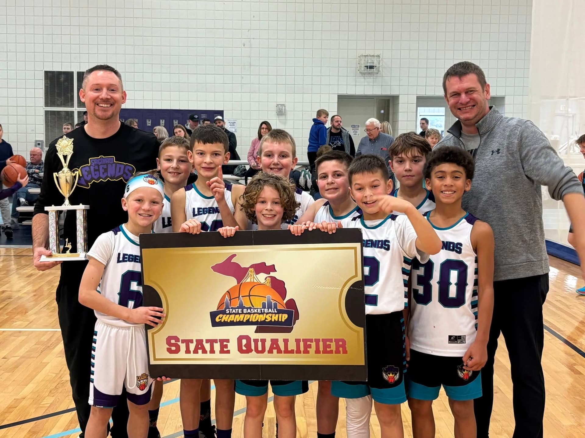Legends team holding State Qualifier banner and first-place trophy